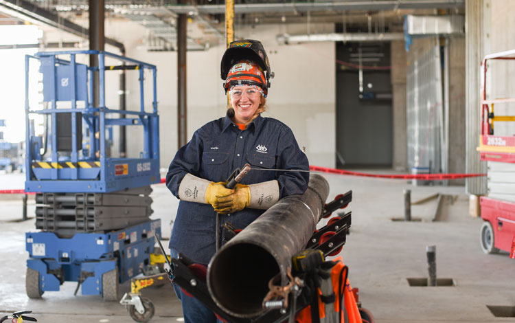 Kaylin Leas Standing next to a pipe.